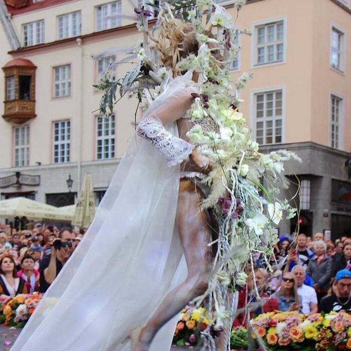 A woman in a white dress is holding a bouquet of flowers.