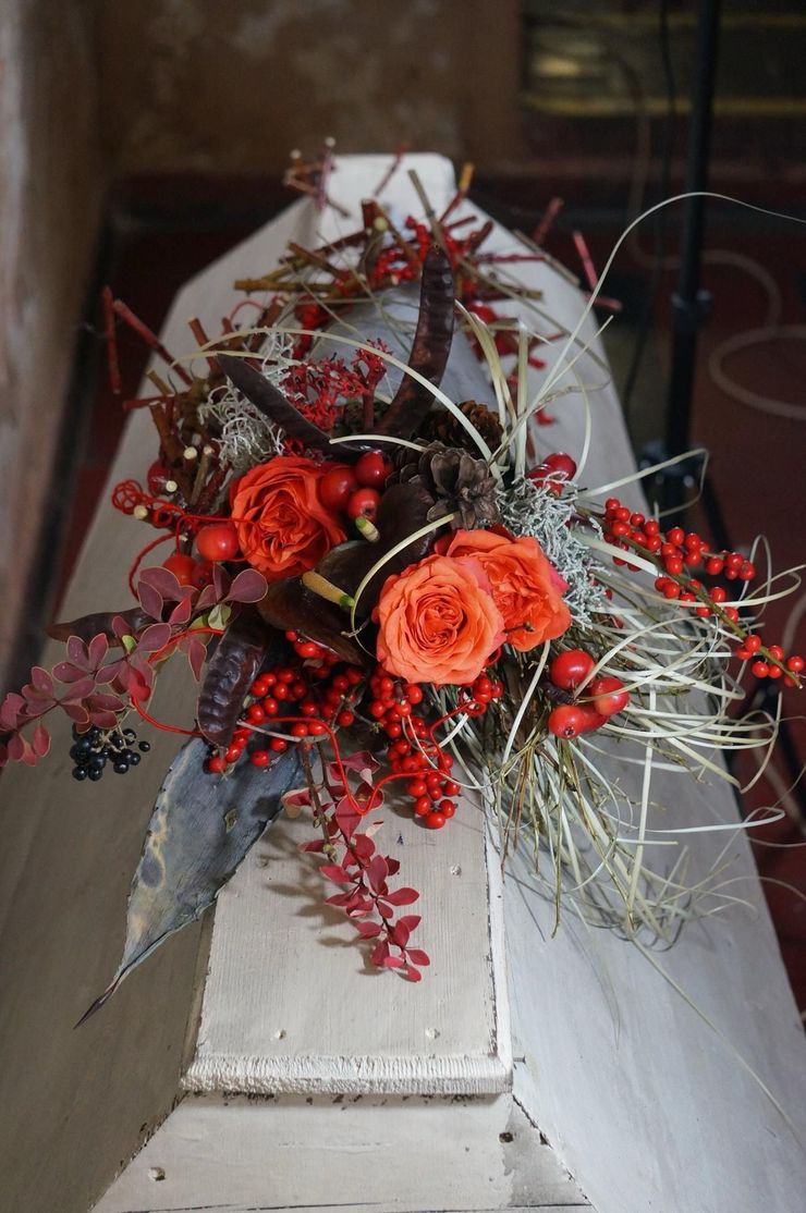 A white coffin with flowers and berries on top.