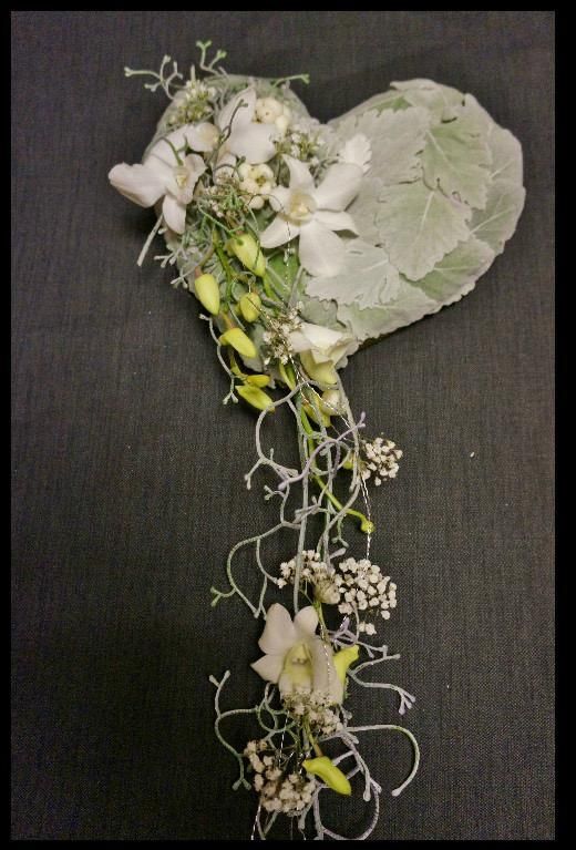 A heart-shaped bouquet of white and green flowers.