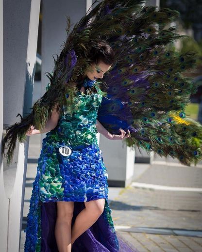 A woman in a peacock costume has the number 70 on her waist