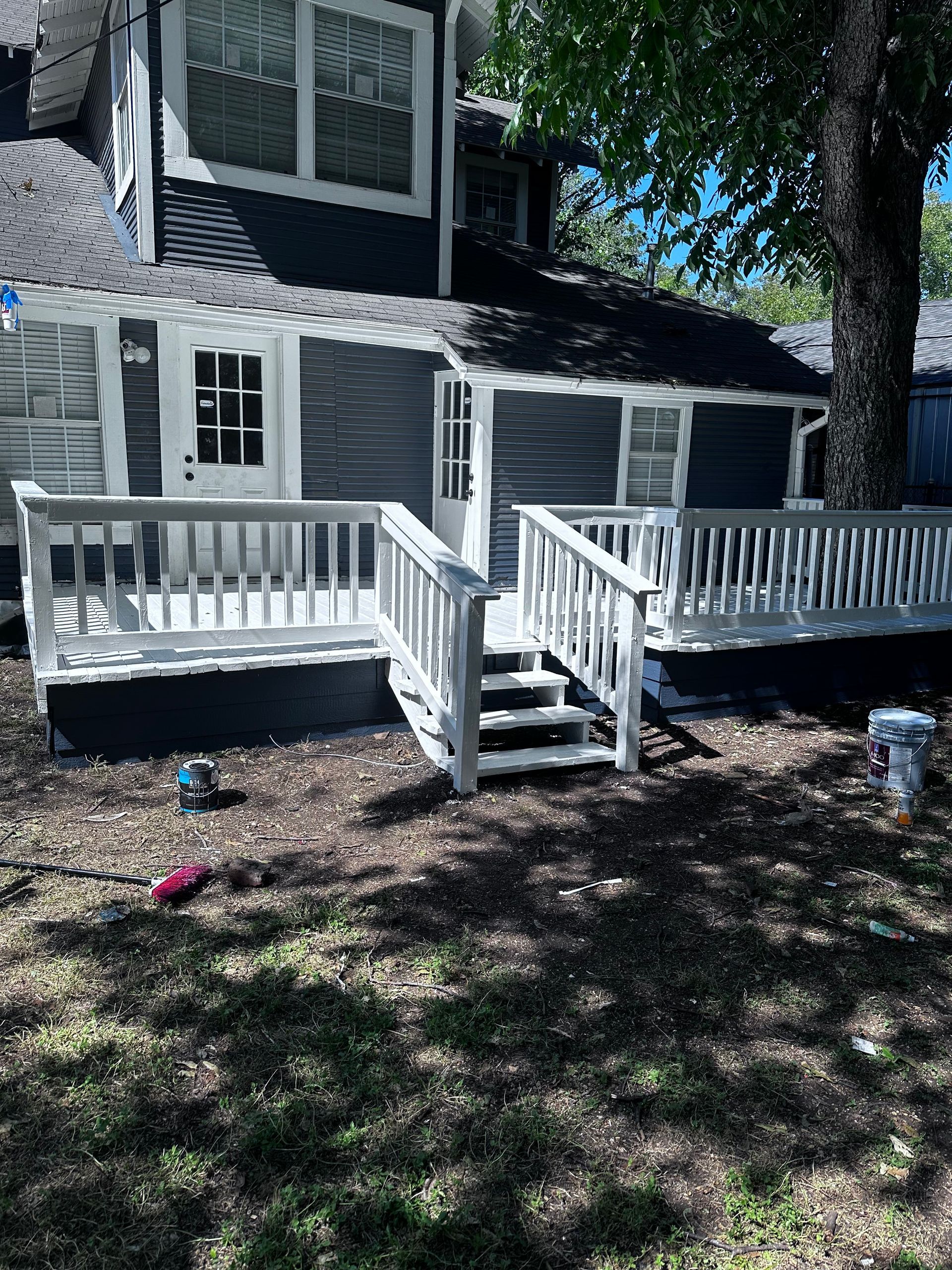 A house with a deck and stairs in front of it