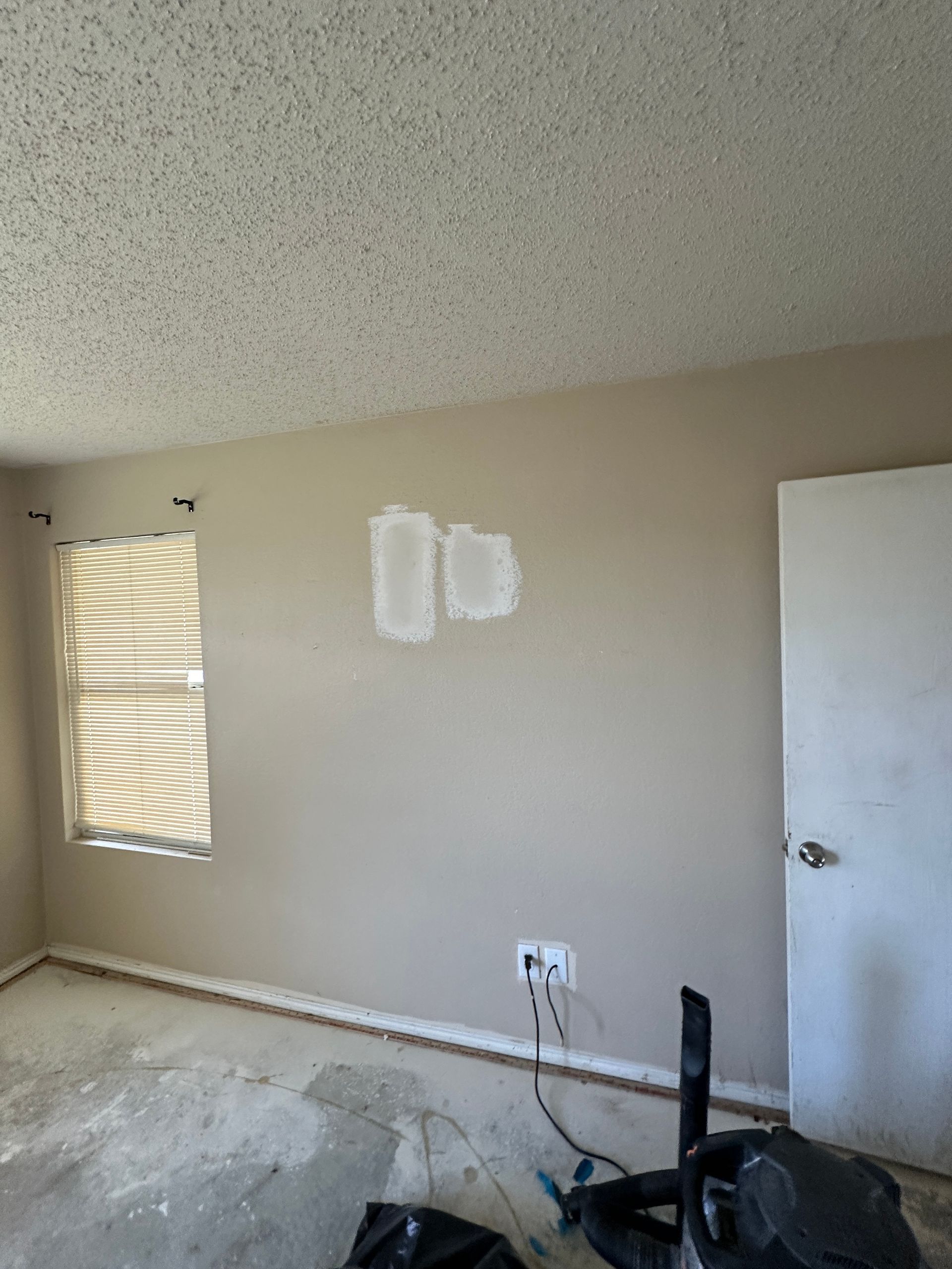 An empty room with two windows and a door.