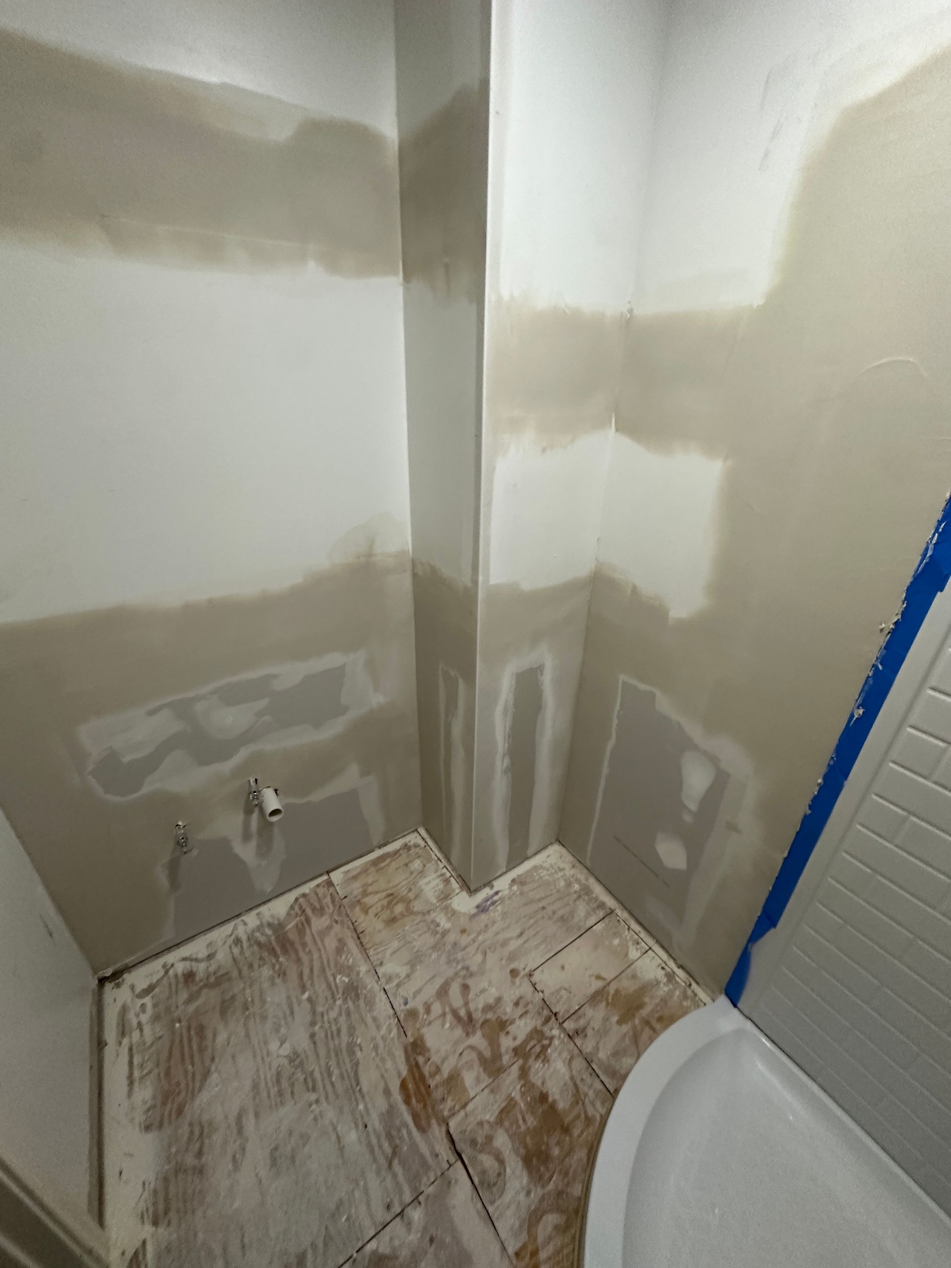 A bathroom under construction with a toilet and a shower.