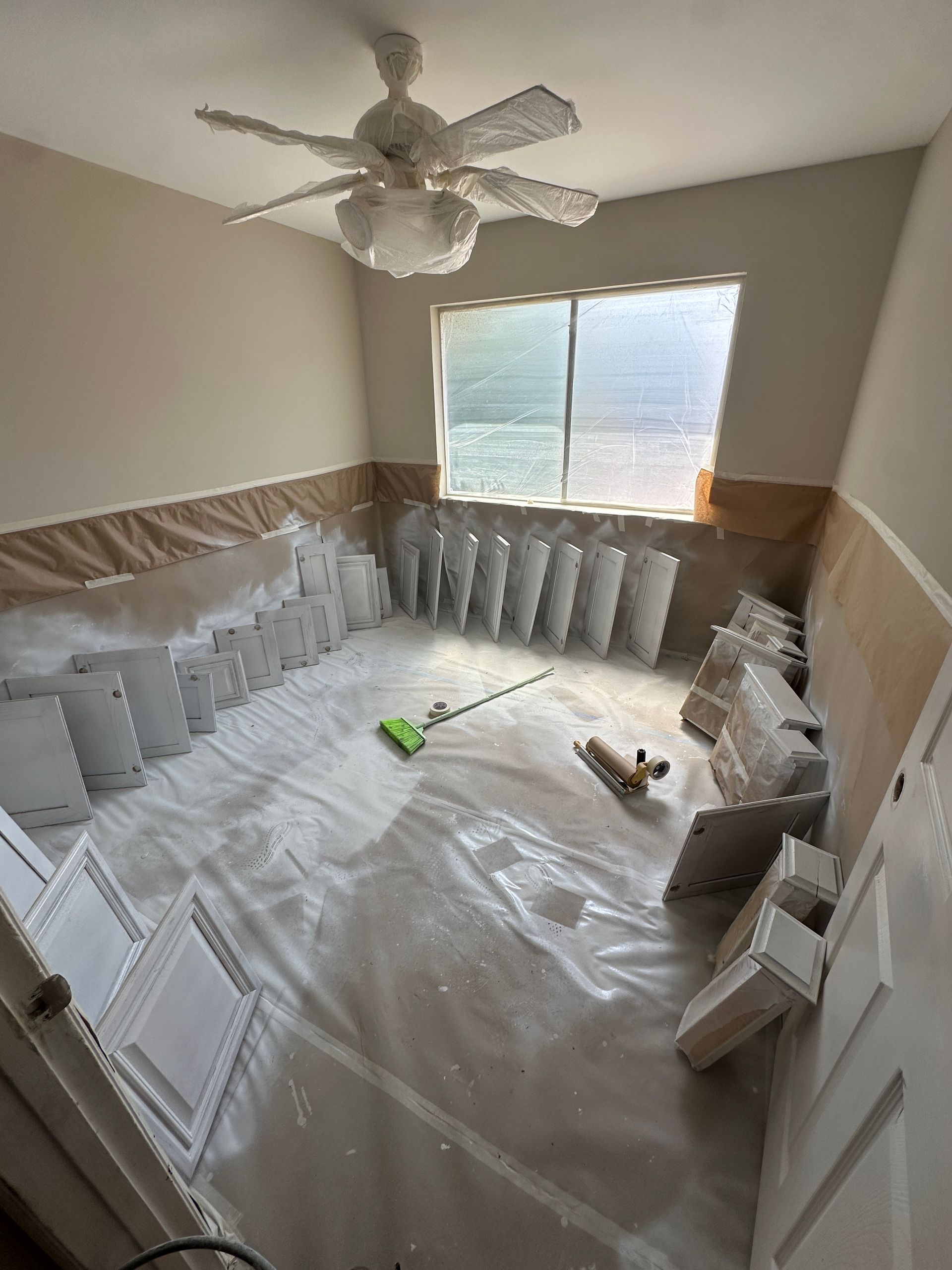 A room with a lot of cabinets and a ceiling fan.