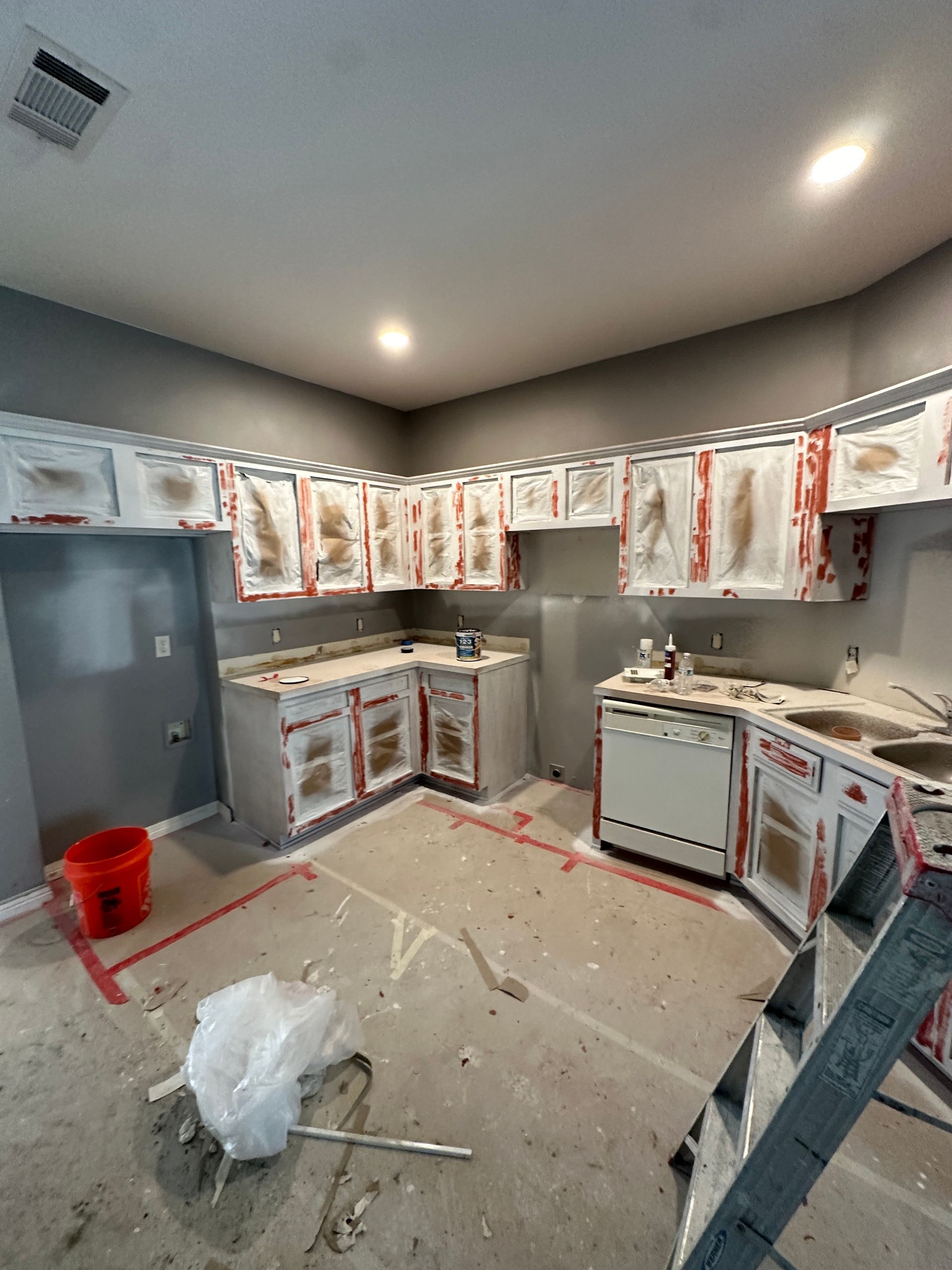 A kitchen under construction with a ladder in the middle of the room.