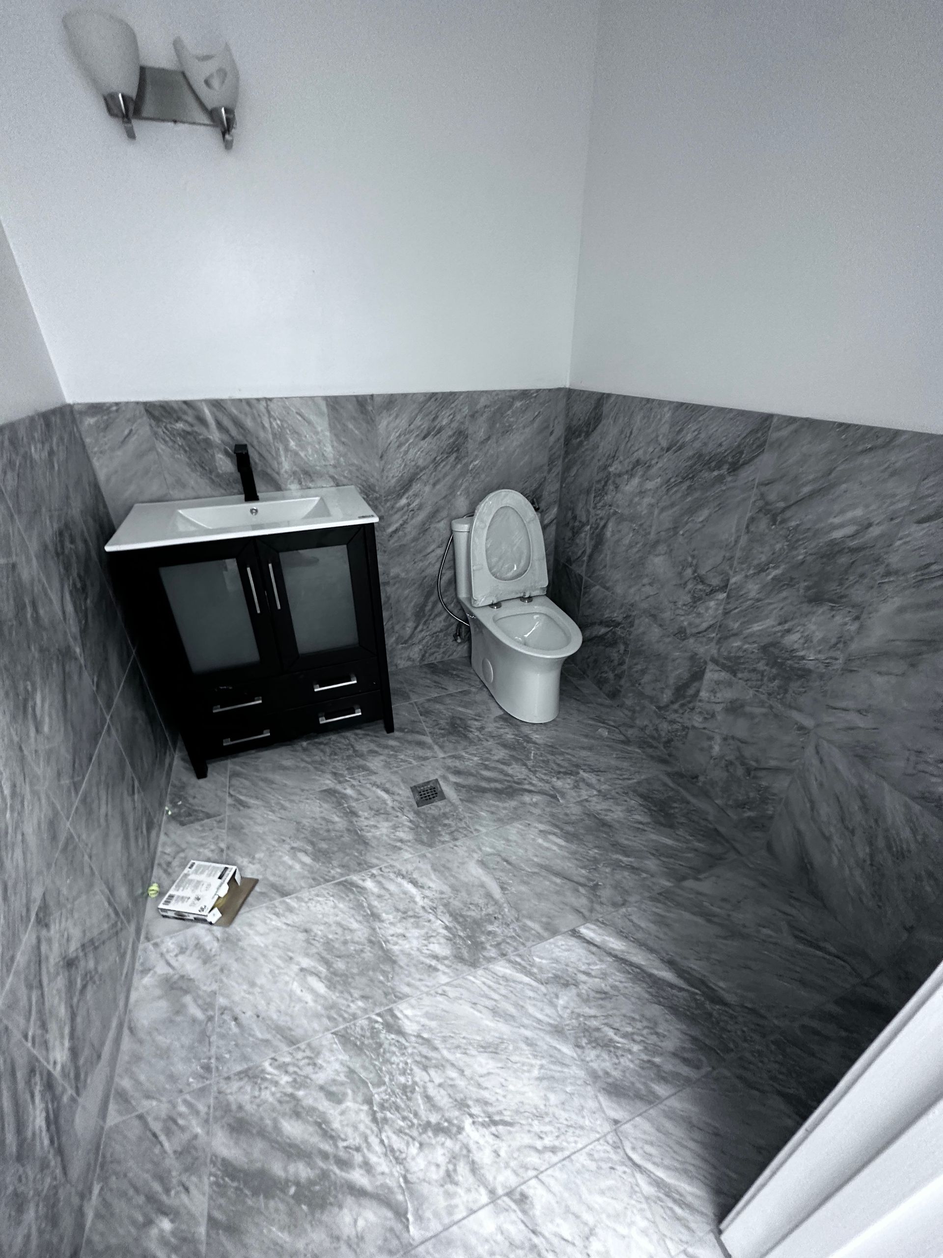 A bathroom with a toilet , sink and vanity.