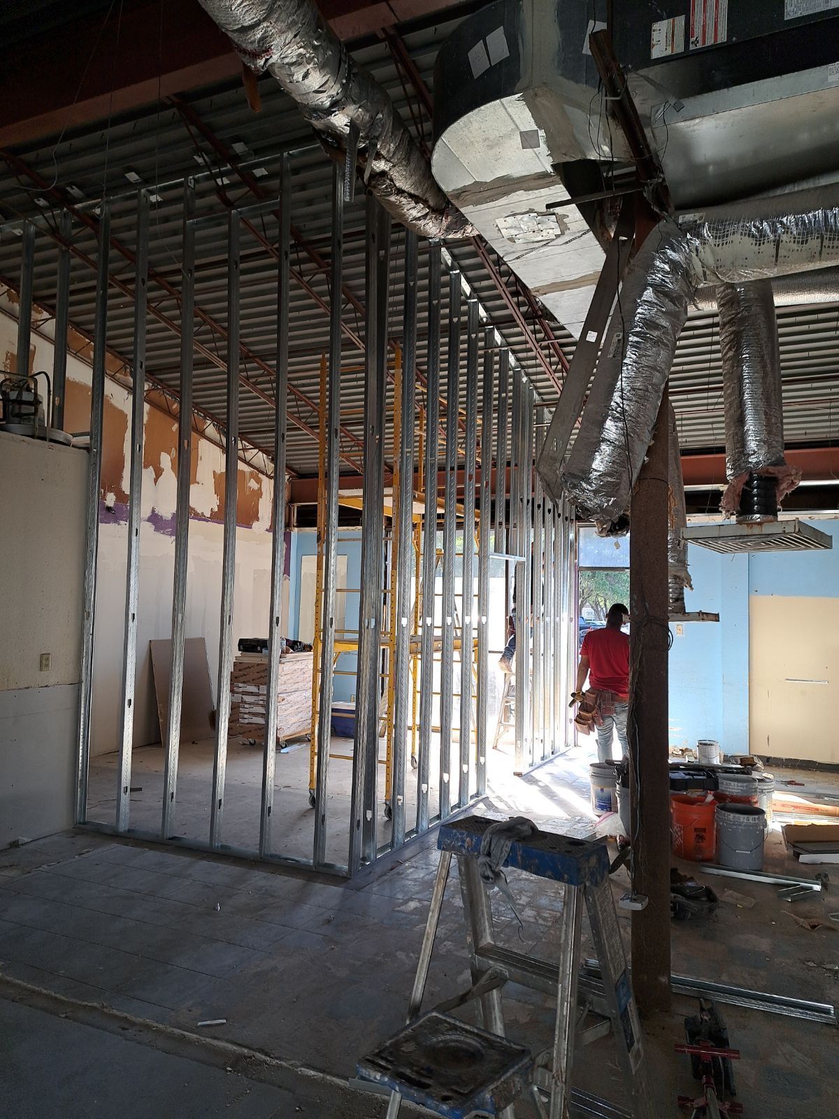 A man is working on a wall in a building under construction.
