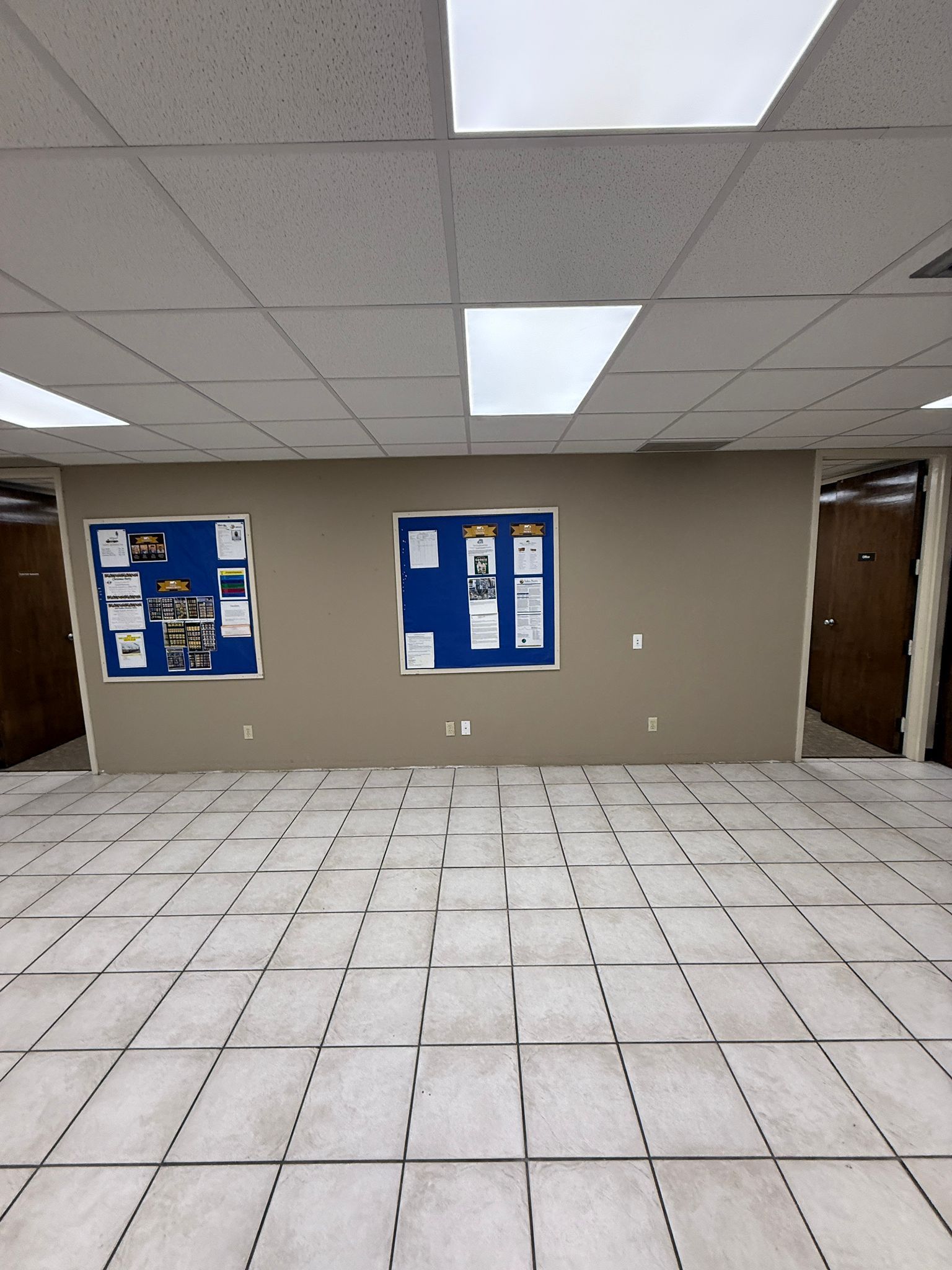 An empty room with two bulletin boards on the wall