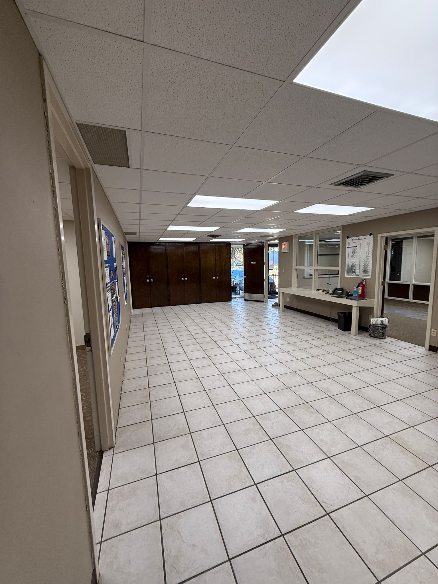 A large empty room with a tiled floor and ceiling