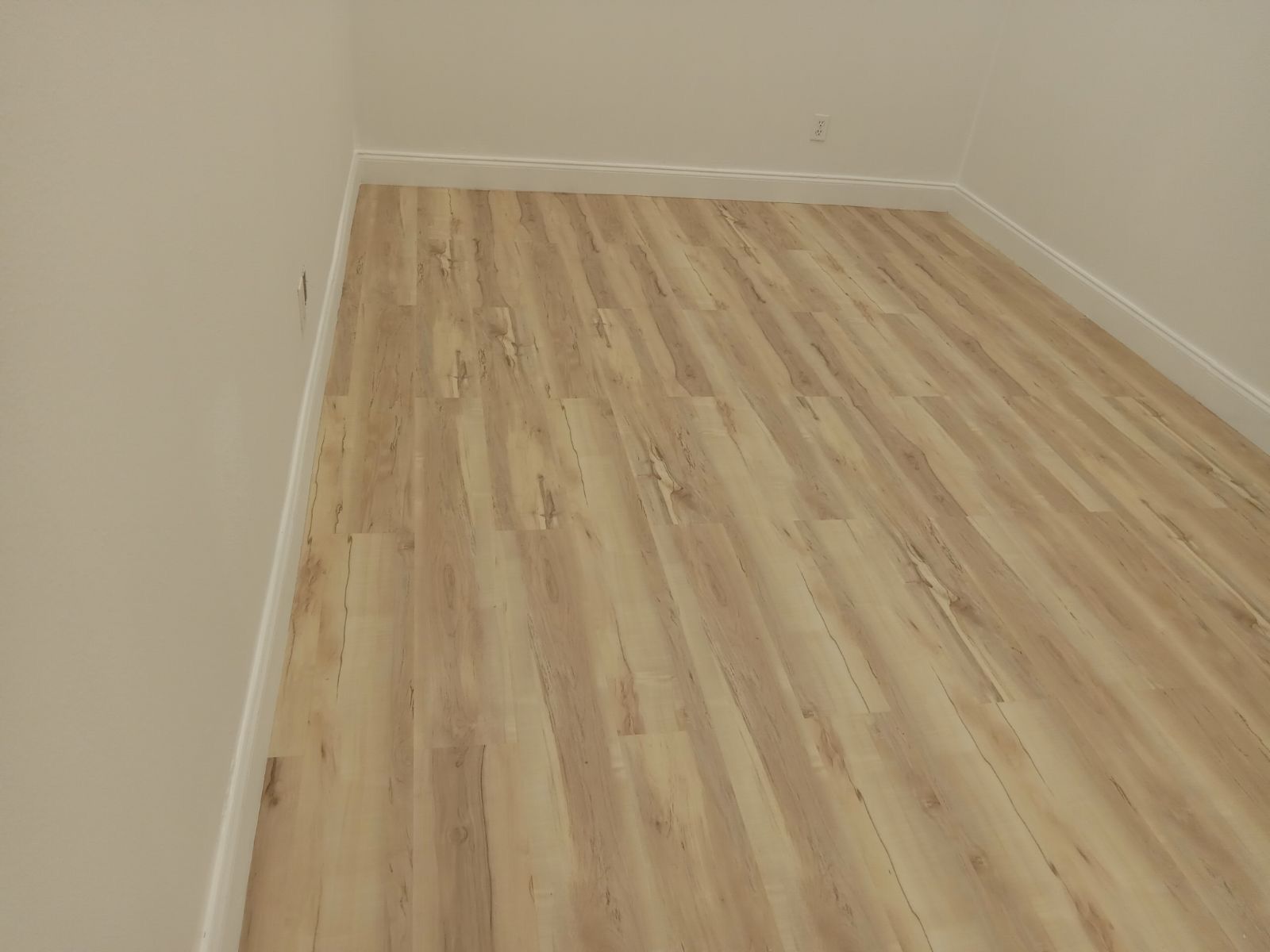 A room with a wooden floor and white walls.