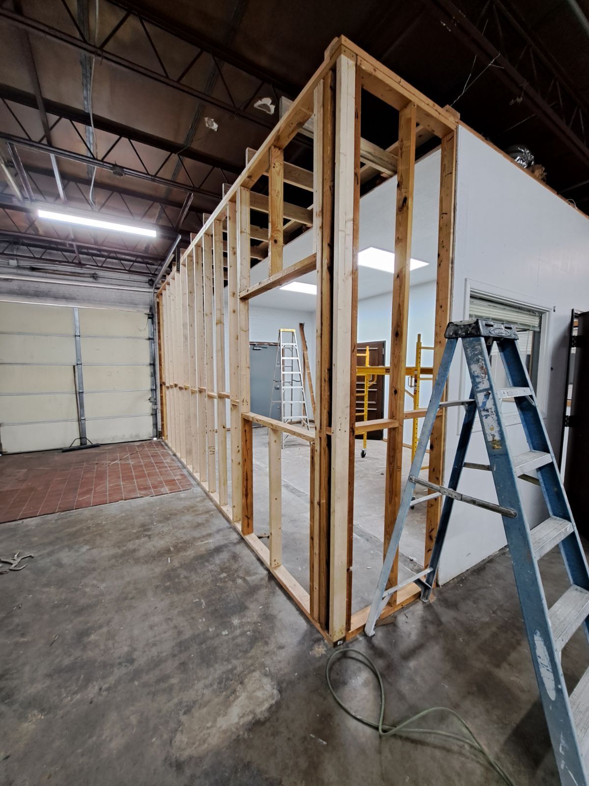 A ladder is sitting next to a wall in a building under construction.