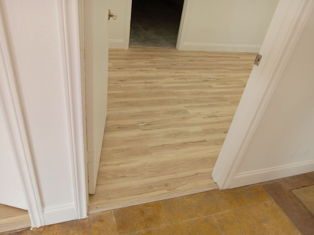 A hallway with a wooden floor and a white door