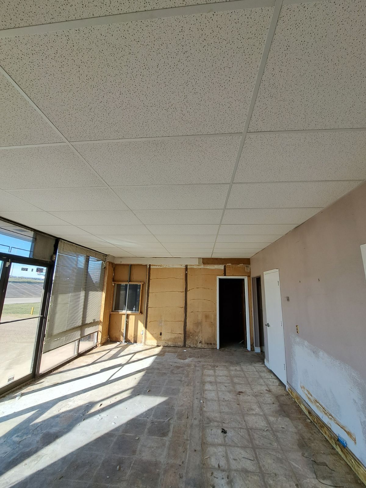 An empty room with a tiled floor and a white ceiling.