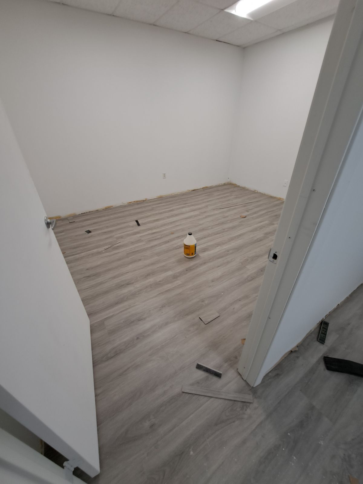 An empty room with a wooden floor and white walls.