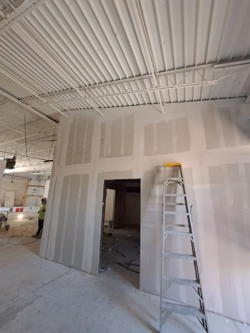 A ladder is leaning against a wall in a room under construction.