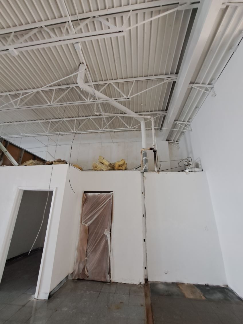 An empty room with white walls and a ceiling.