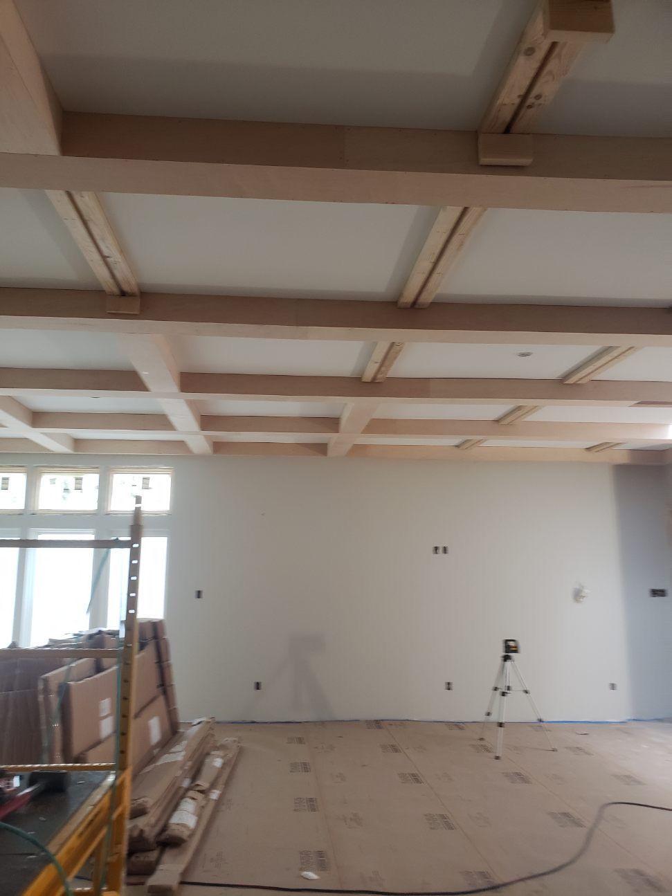 A room that is being remodeled with wooden beams on the ceiling