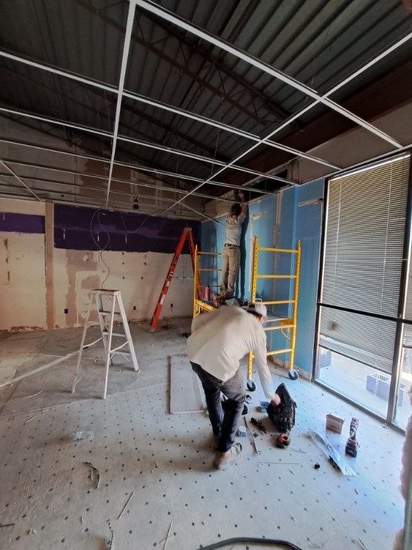 A man is working on the ceiling of a building