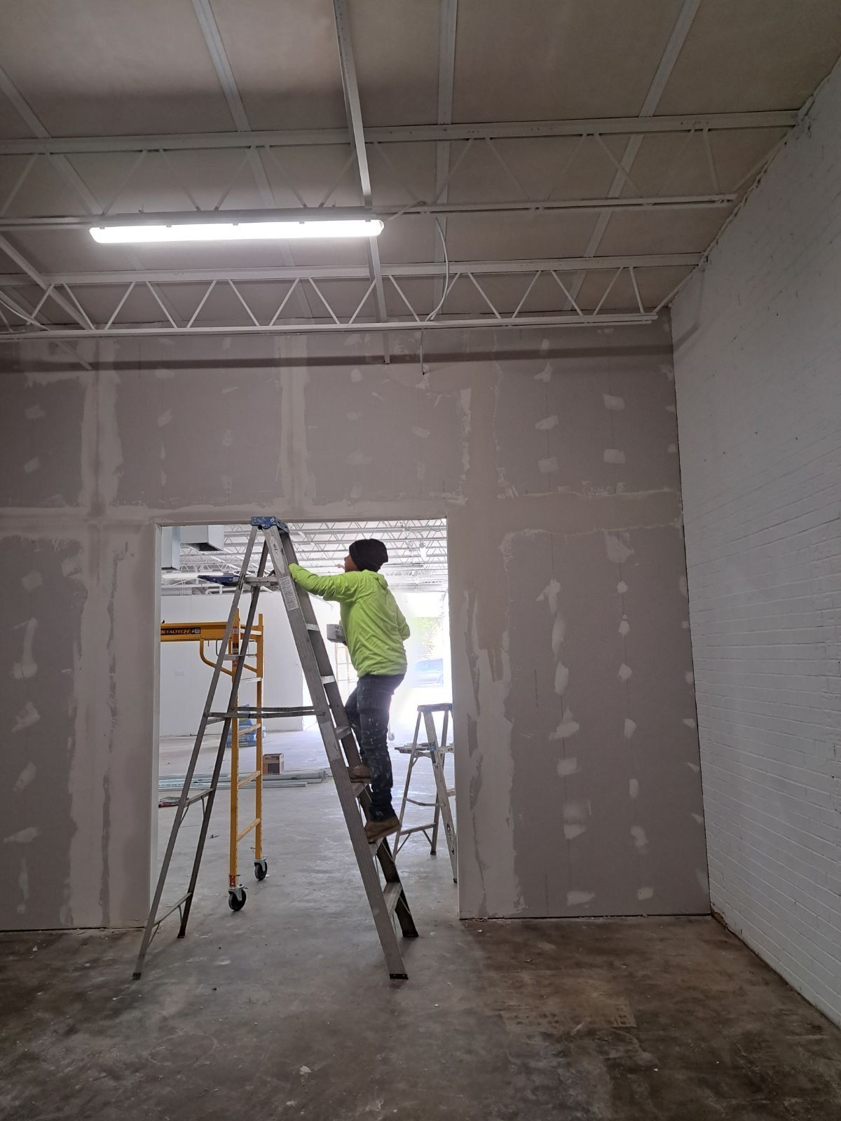 A man is standing on a ladder in a room.
