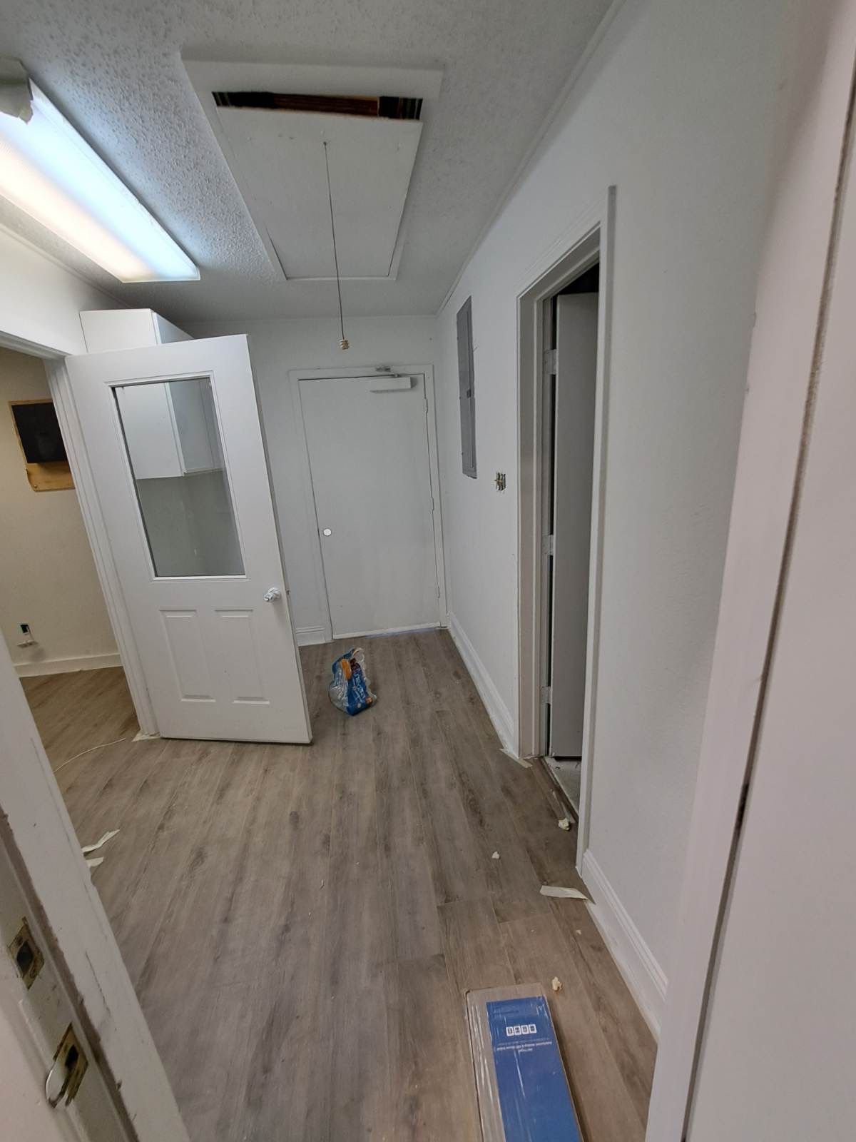 An empty hallway with hardwood floors and white walls.