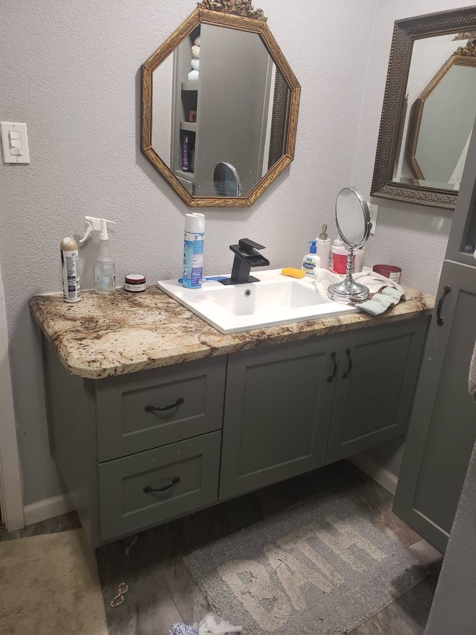 A bathroom with a sink , mirror , and cabinets.