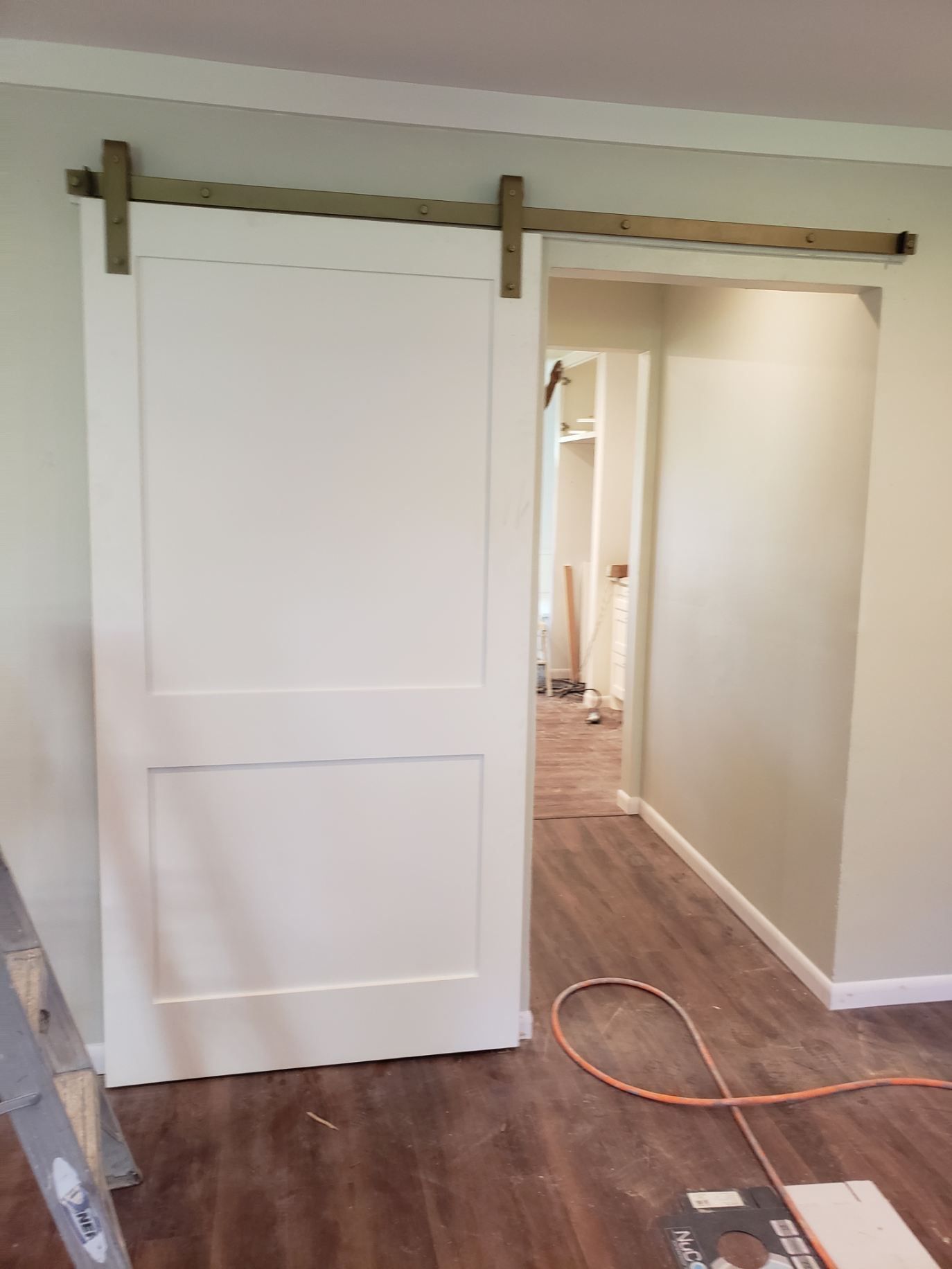 A sliding barn door is being installed in a room.