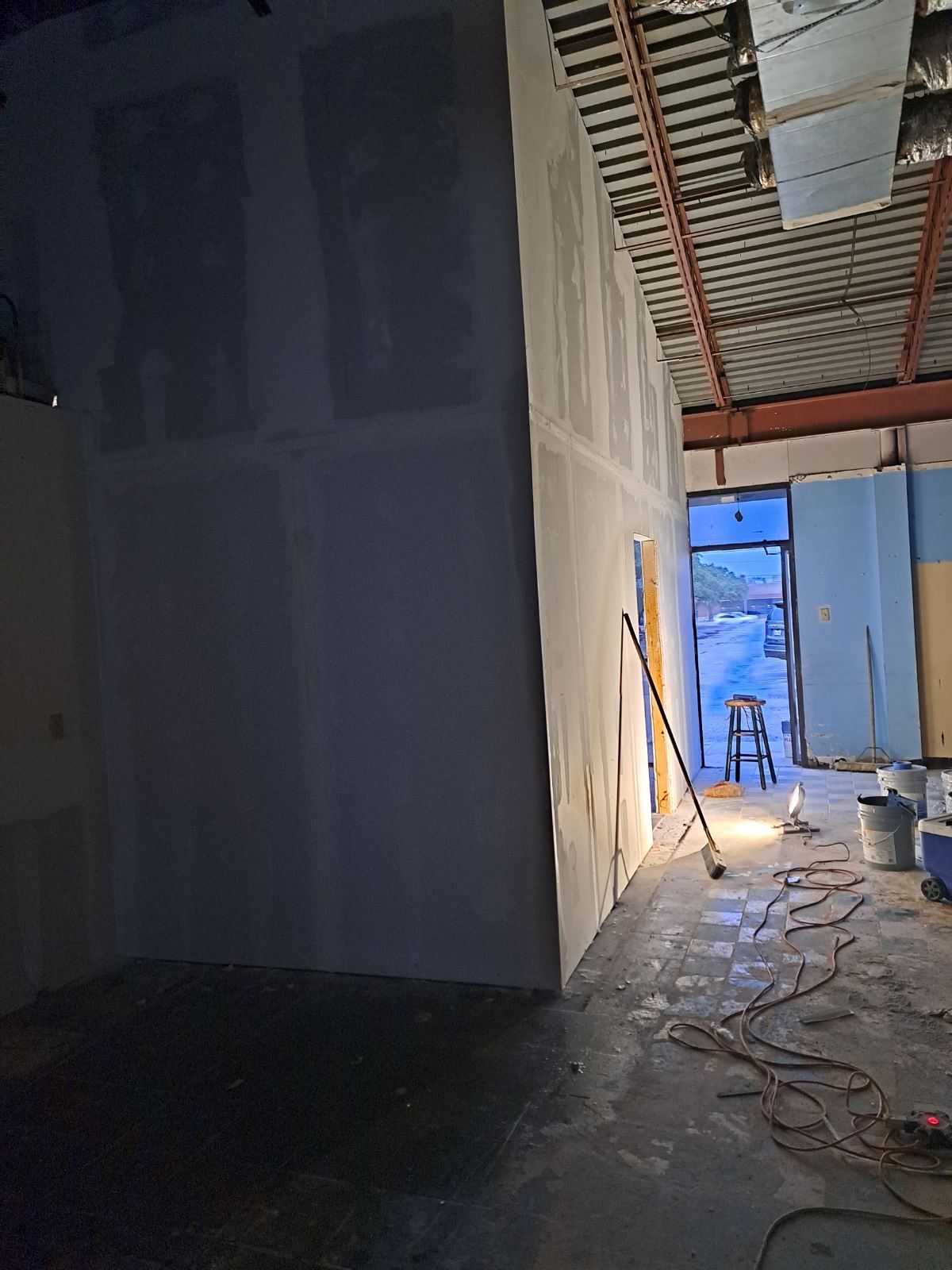 A room with a ladder and a vacuum cleaner in it is being remodeled.