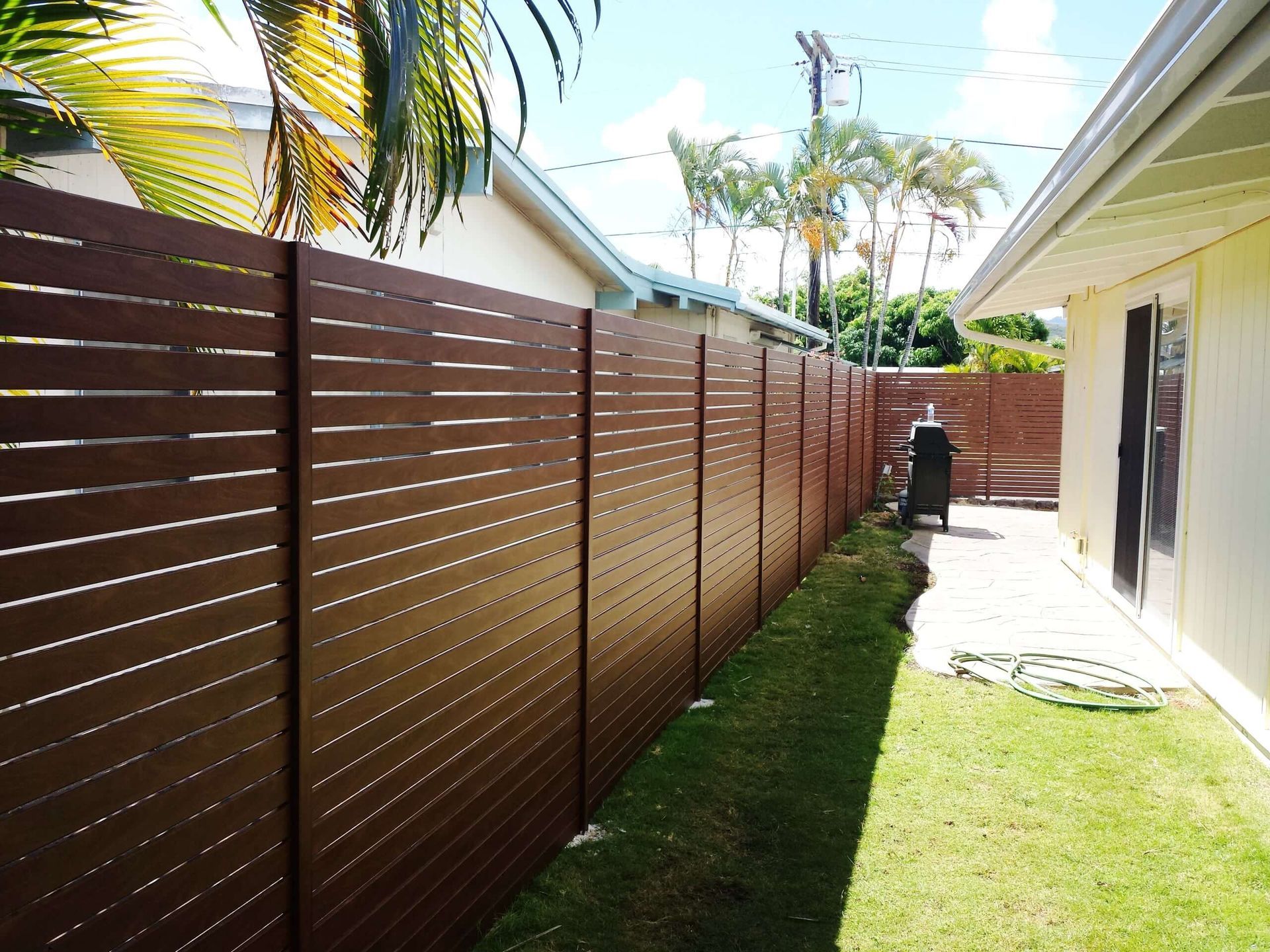 A wooden fence along the side of a house