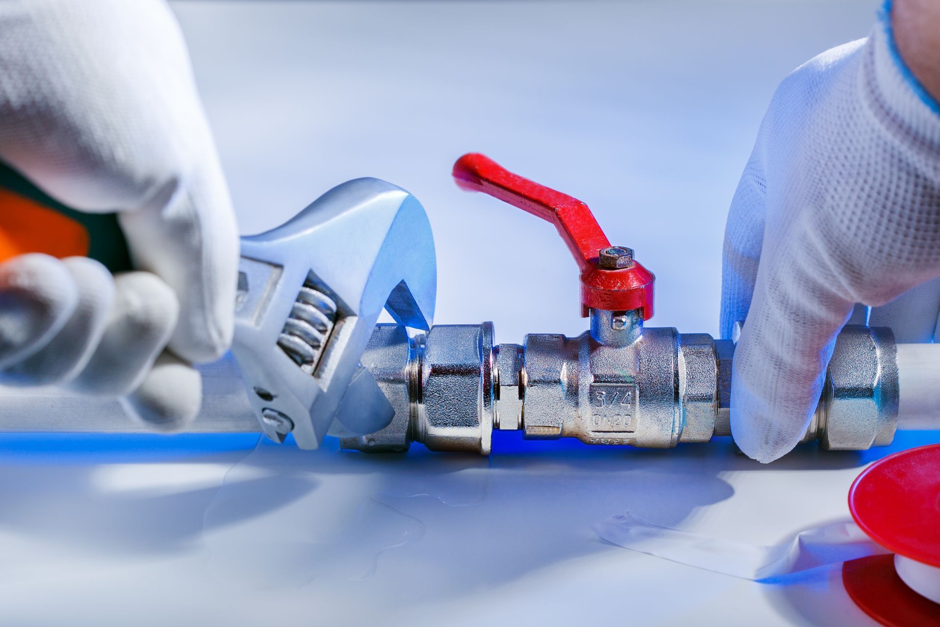 Glass shower enclosure with black tiled floor and drain.