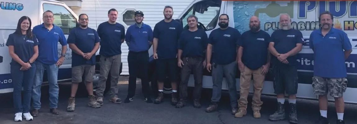 Plumber working under a bathroom sink, surrounded by tools and a bucket.