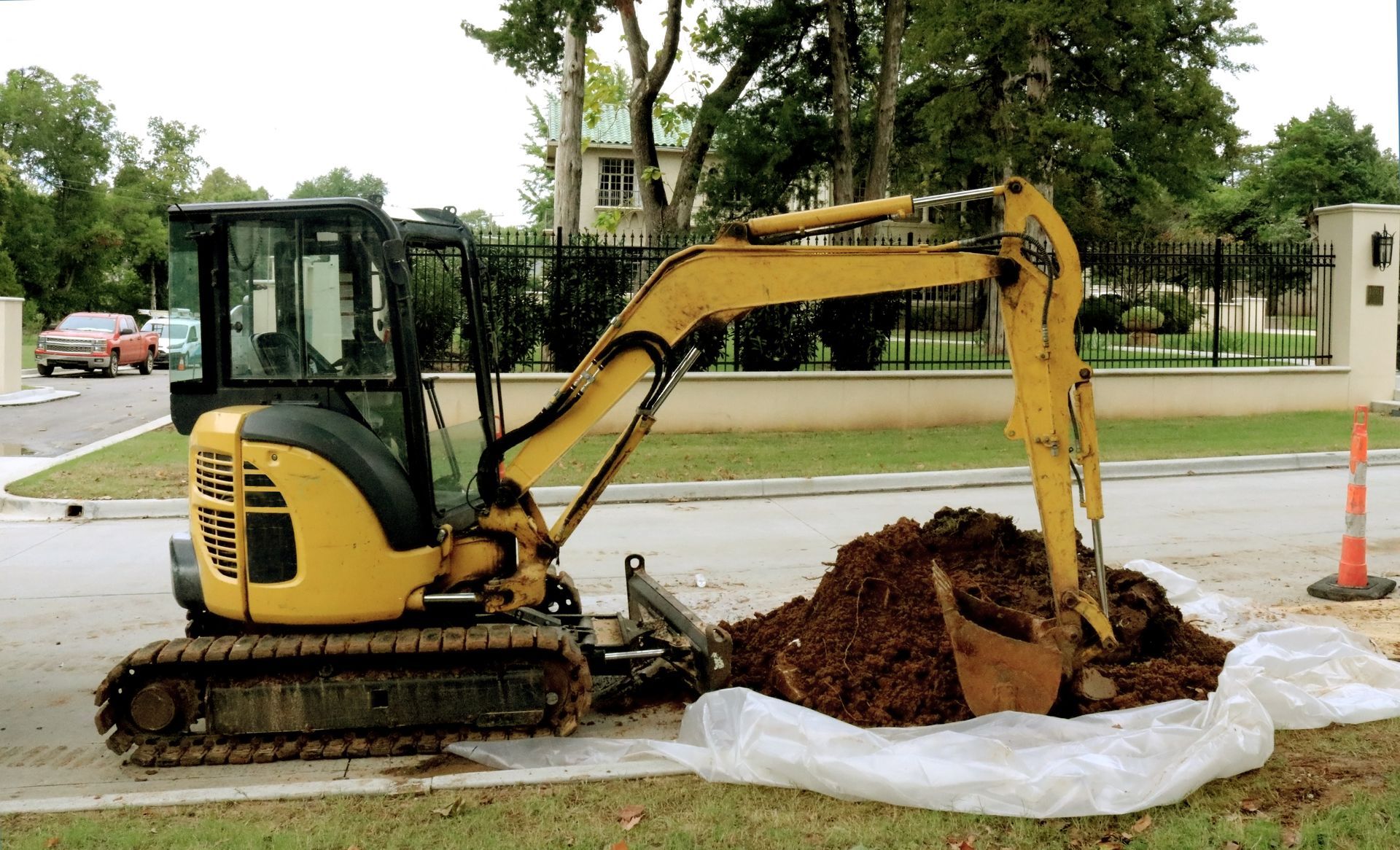 A yellow excavator is digging a hole in the ground