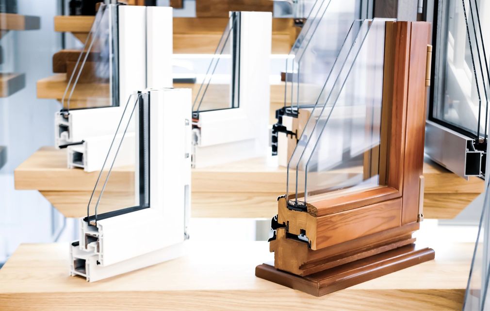 Infissi moderni in legno e bianco esposti su un tavolo da showroom.