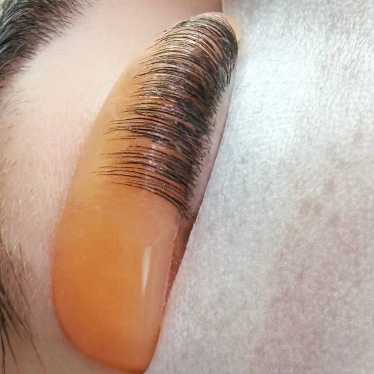 A close up of a woman 's eye with long eyelashes.