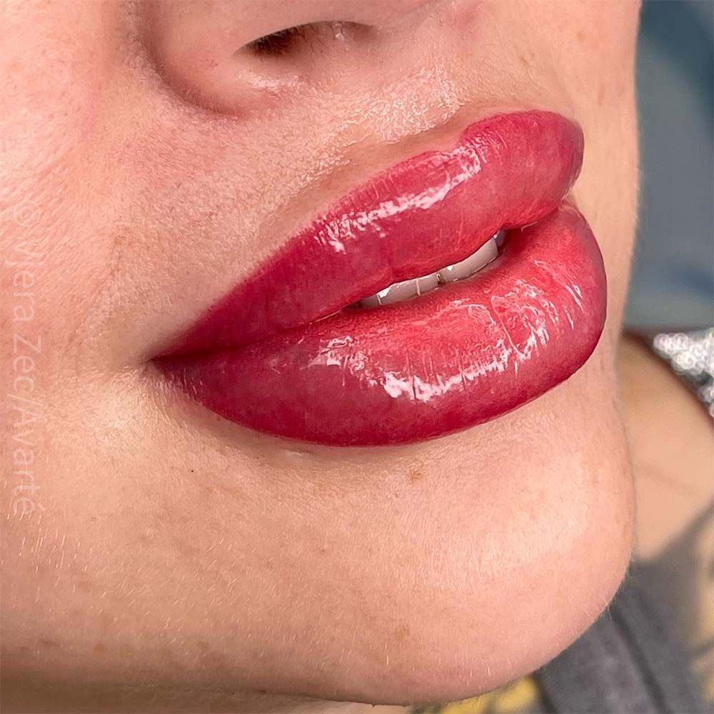 A close up of a woman 's lips with red lipstick.