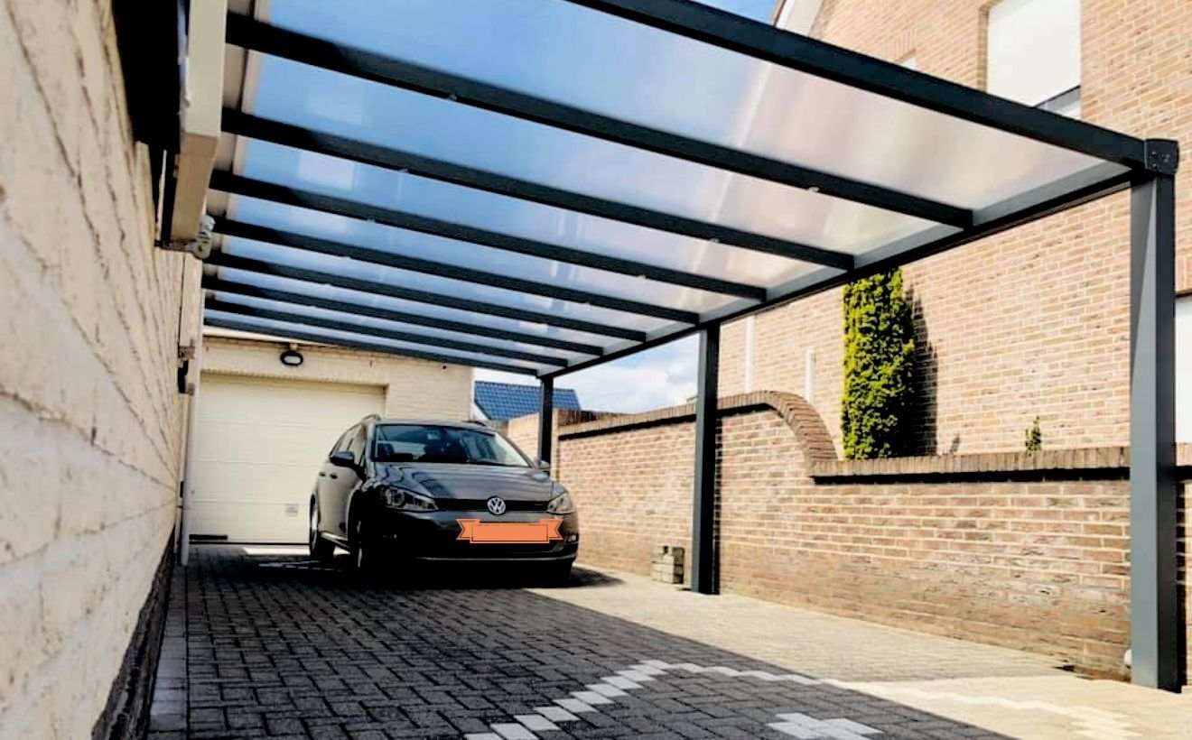 Een auto staat geparkeerd onder een afdak op een oprit.