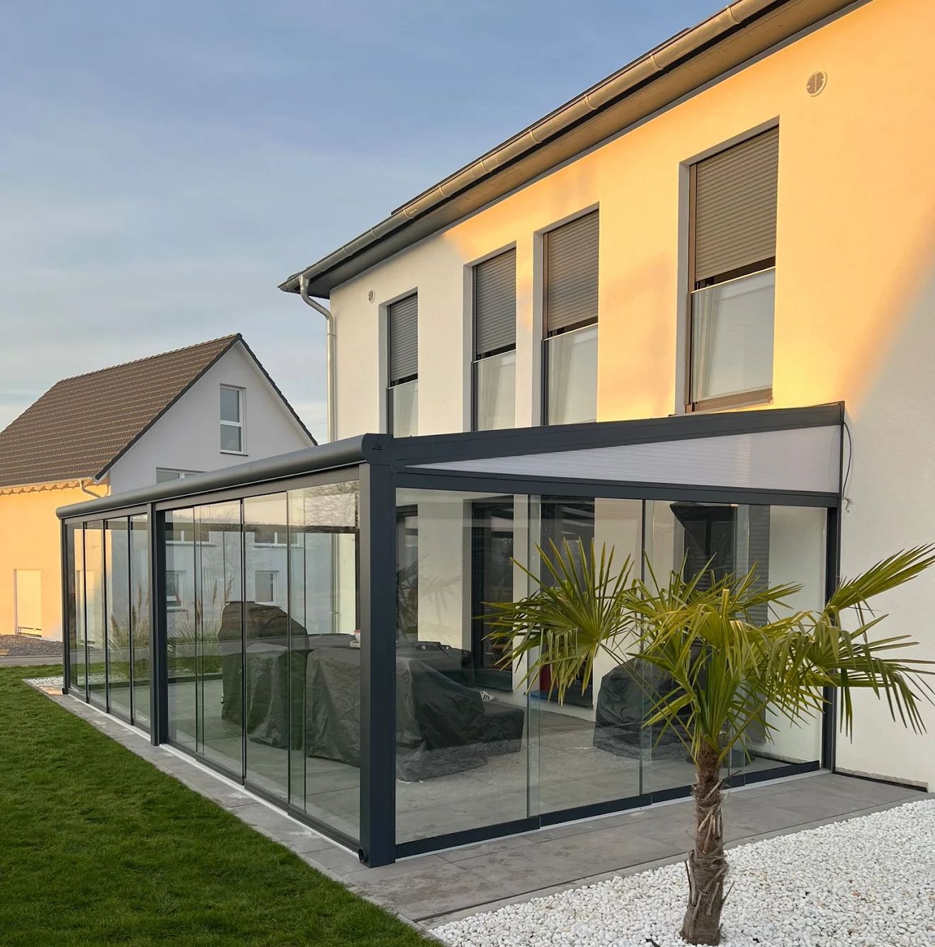 Een terras met glazen schuifdeuren en een tafel en stoelen voor een gebouw.