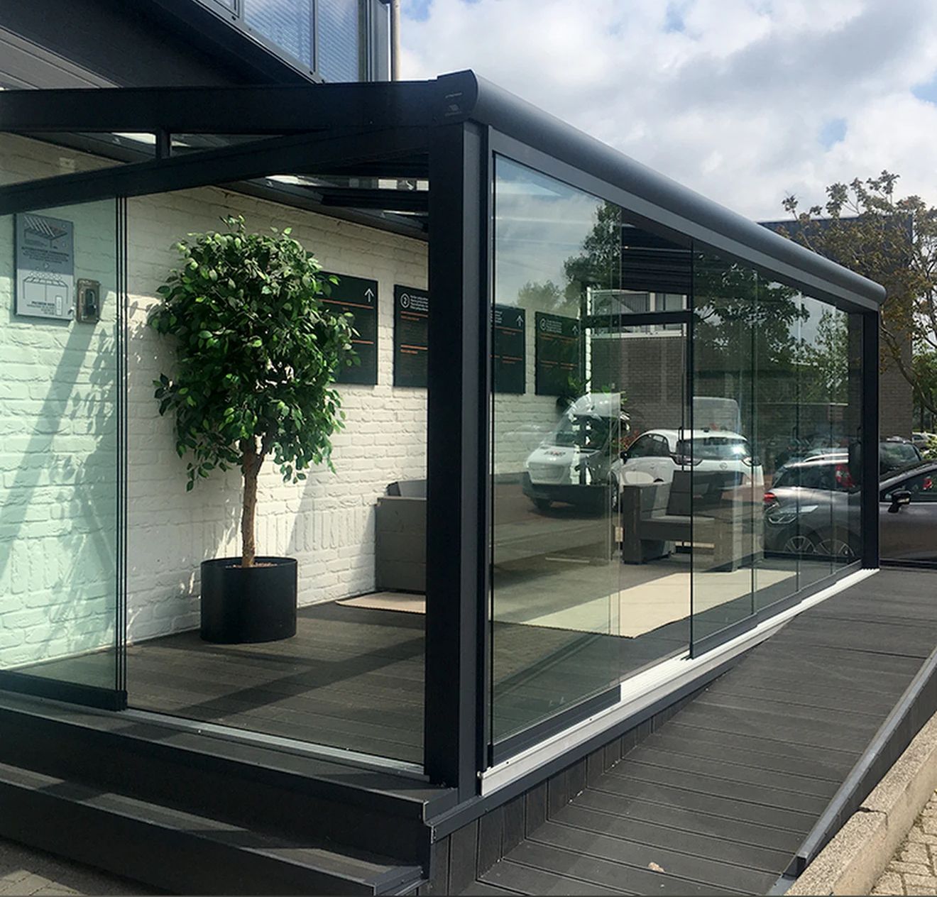 Een kamer met veel glazen deuren die naar een patio leiden.