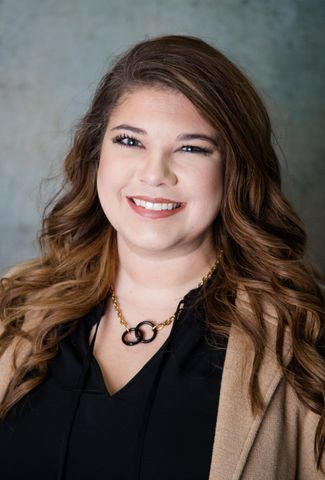 The woman is wearing a black shirt and smiling for the camera.