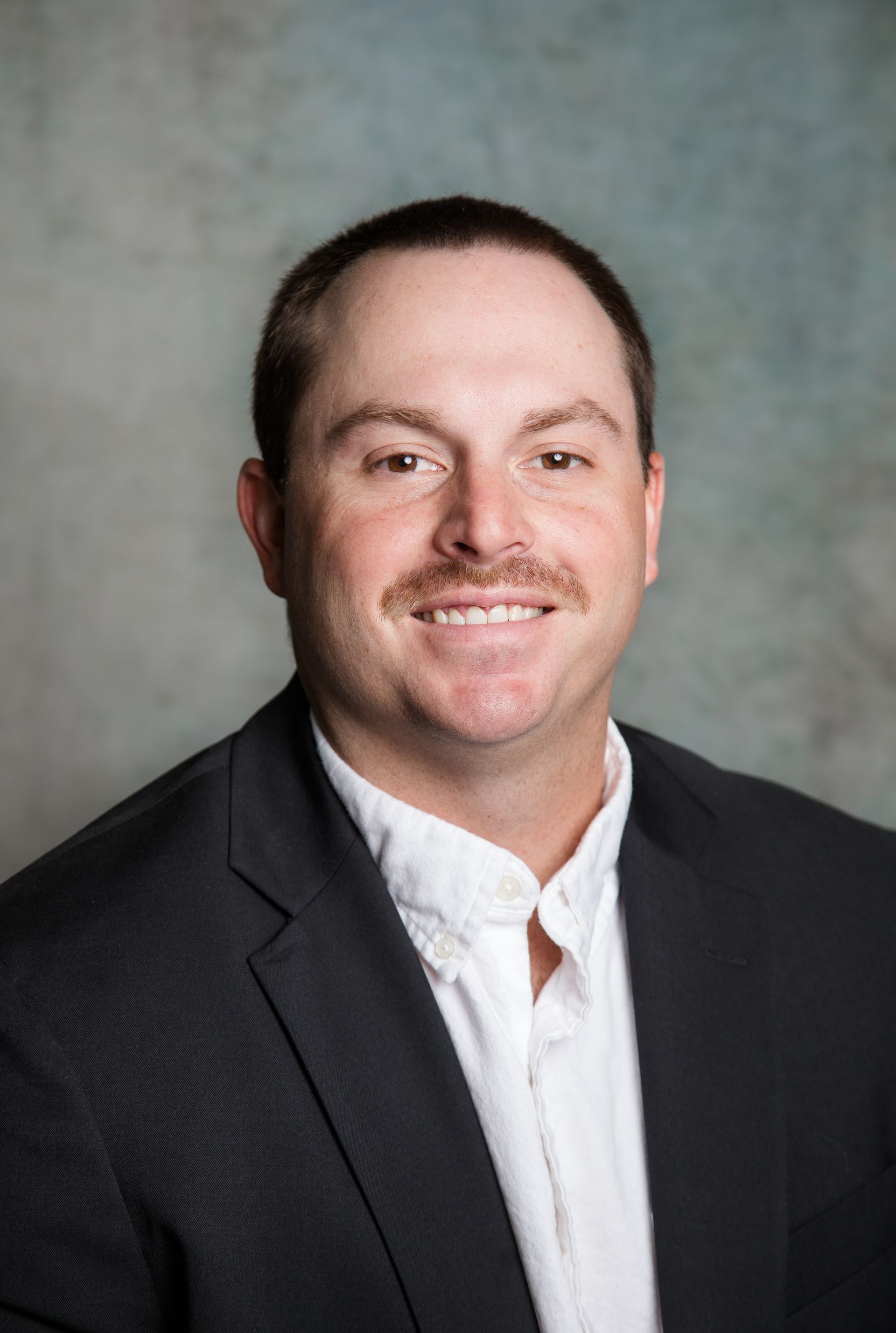 The woman is wearing a black shirt and smiling for the camera.