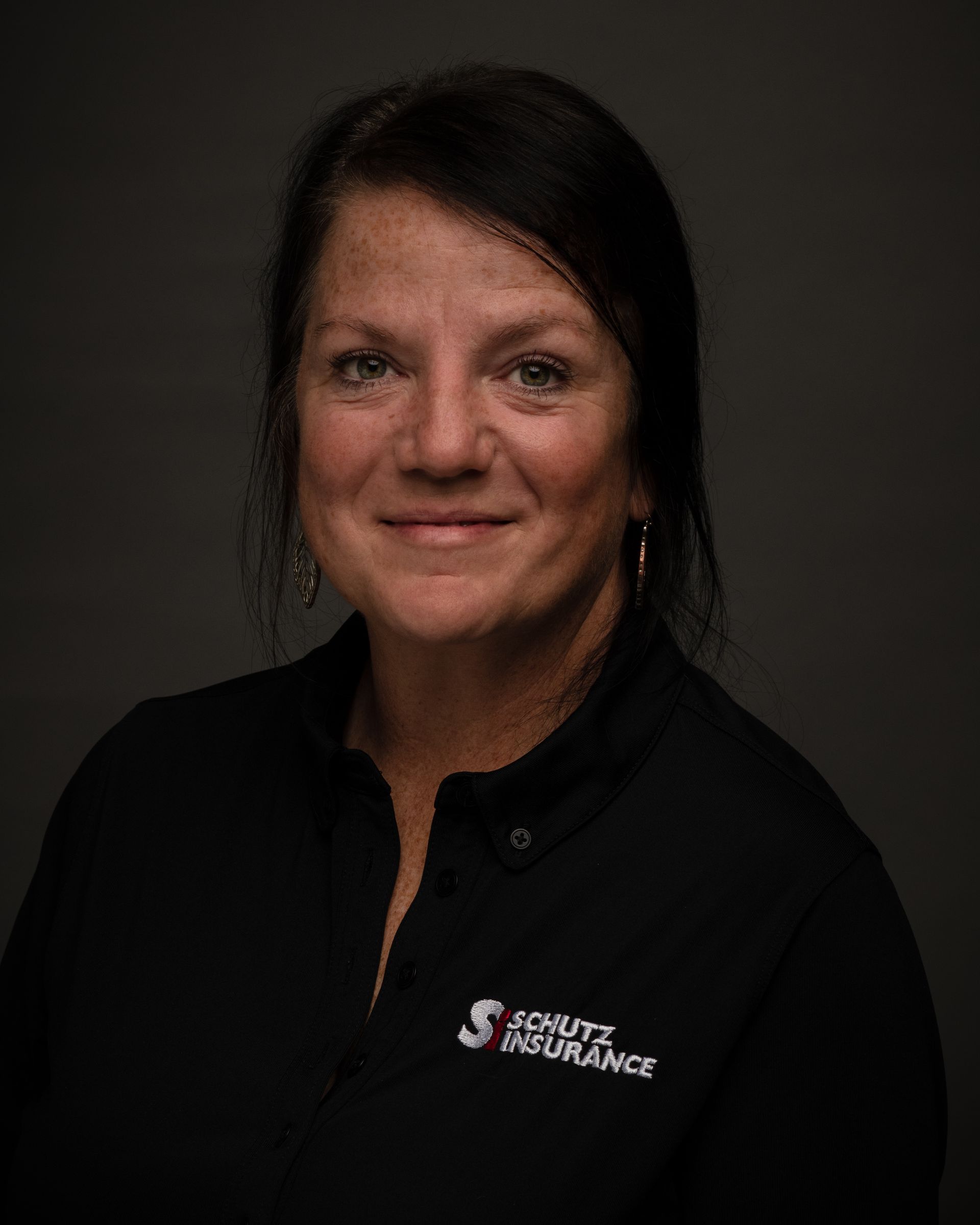 The woman is wearing a black shirt and smiling for the camera.