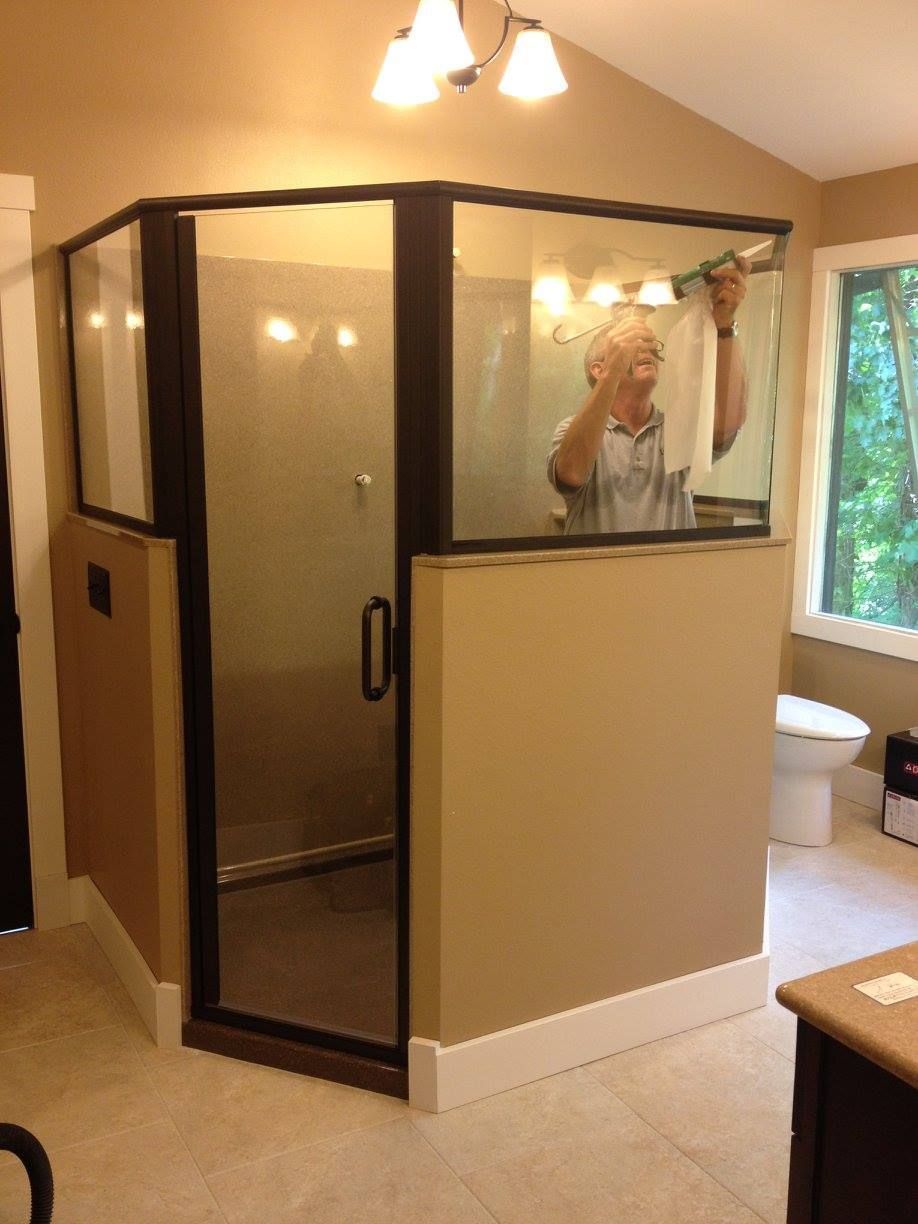 A man is taking a picture of himself in a shower stall
