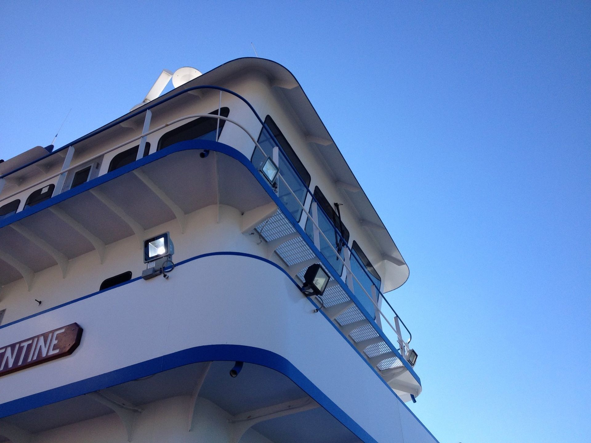 Looking up at the top of a white and blue building with a sign that says welcome