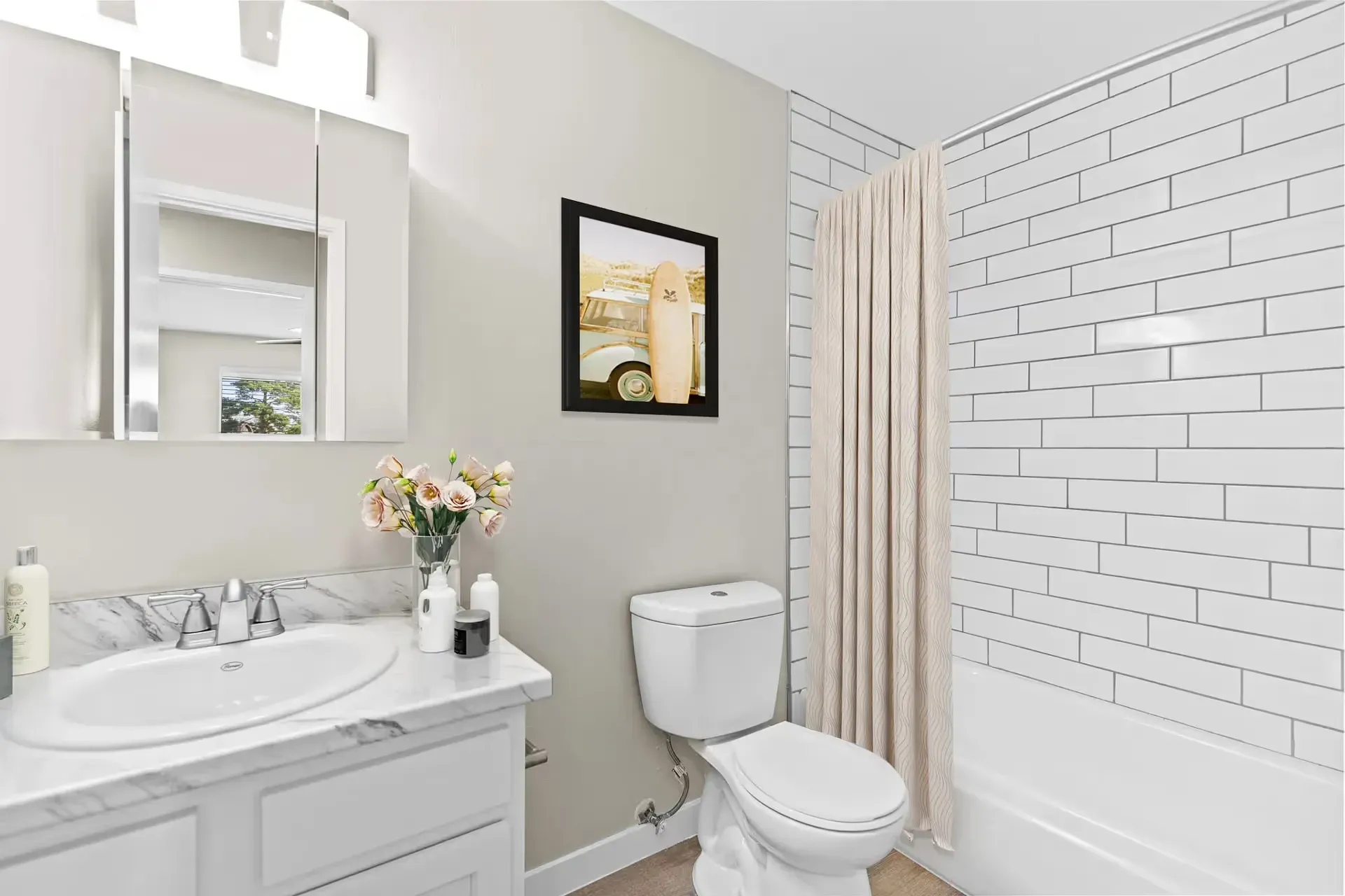 Modern bathroom with marble countertop, sink, toilet, and tiled shower.