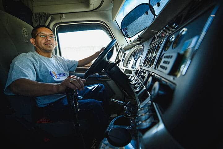 Un hombre está sentado en el asiento del conductor de un camión.