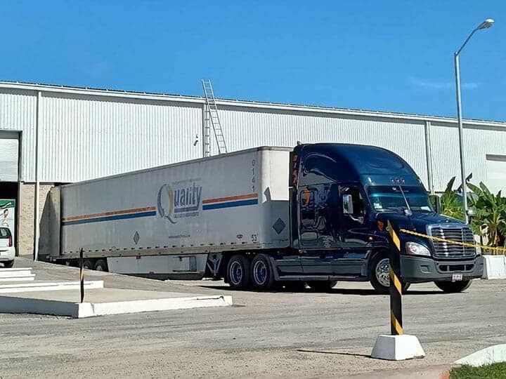 Un gran camión está estacionado frente a un edificio.