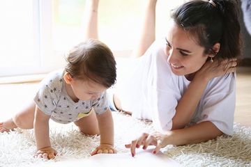 Mother Reading a Book to Her Baby — Saint Cloud, MN — Bart’s Carpet Clean Systems LLC