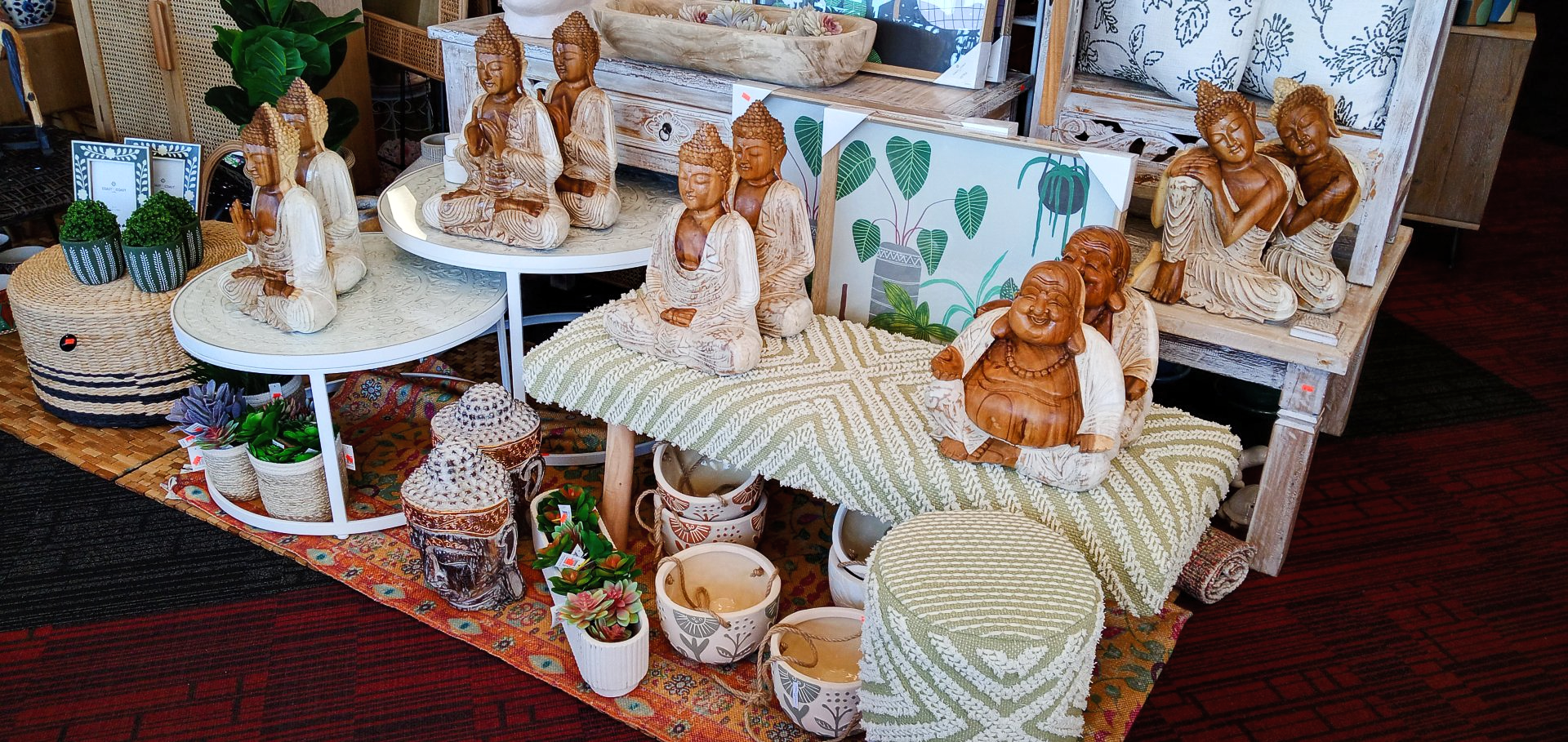 A table with a bunch of statues and potted plants on it.