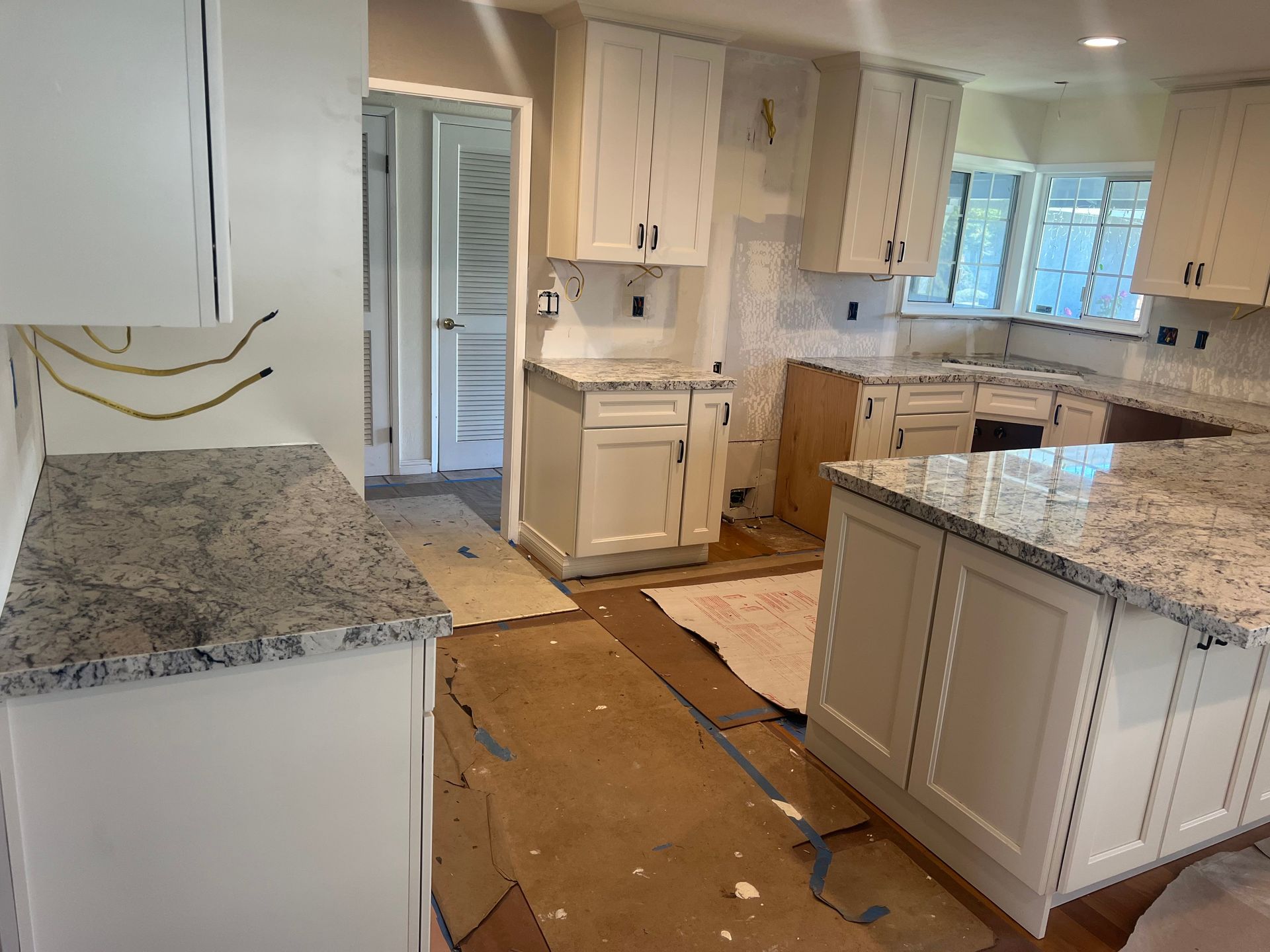 A kitchen with a wooden table and chairs and a vase of flowers on it — San Leandro, CA — Mission Flooring and Countertop Design