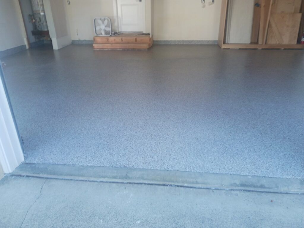 A garage with a gray floor and a fan on the floor — San Leandro, CA — Mission Flooring and Countertop Design