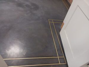A white door is sitting next to a black floor — San Leandro, CA — Mission Flooring and Countertop Design